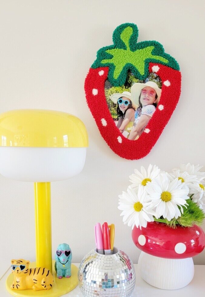 A diy tufted strawberry frame in a tween girl's room.